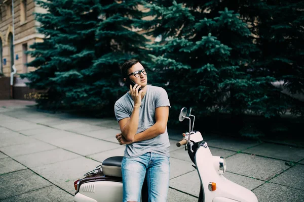 Νεαρά ομορφιά όμορφος άνδρας κάθεται σχετικά με τη μοτοσικλέτα που μιλάει στο τηλέφωνο — Φωτογραφία Αρχείου