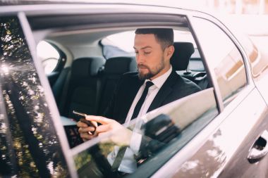 Mobil telefonda konuşurken ve pencere dışında bir taksi arka koltuğunda otururken arıyorum iş adamı. Erkek iş yürütme bir araba ile seyahat ve telefon görüşmesi.