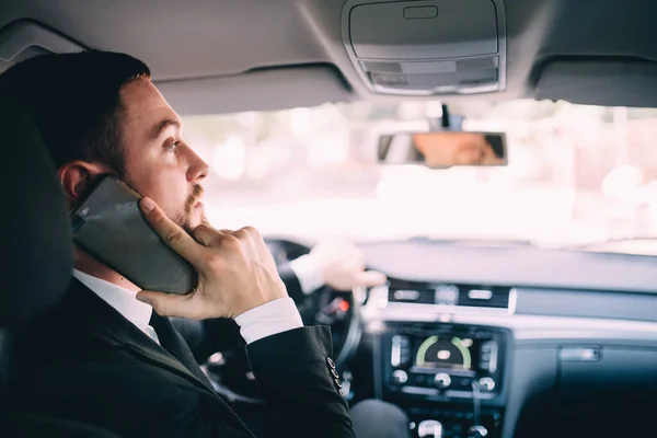 Business Man using his phone while driving the car — Stock Photo, Image