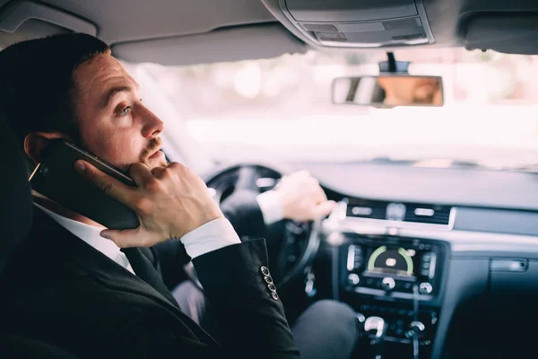 Business Man using his phone while driving the car — Stock Photo, Image