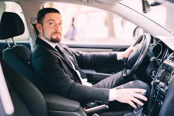 Primer plano de hombre joven en traje coche de conducción — Foto de Stock