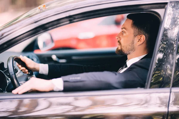 Portrait of young businessman driving a car — Stock Photo, Image