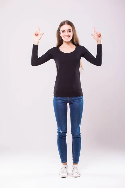 Retrato de mujer elegante apuntando hacia arriba mientras está de pie y sonriendo a usted con la cara divertida sobre fondo blanco aislado — Foto de Stock