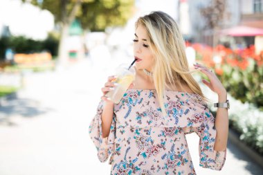 Soğuk tankerin açık havada güzel kızla. Hippi kız içki şehir sokak üzerinde fincan gülümseyen. Sokakta bir milkshake yudumlarken dalgın mutlu kadın