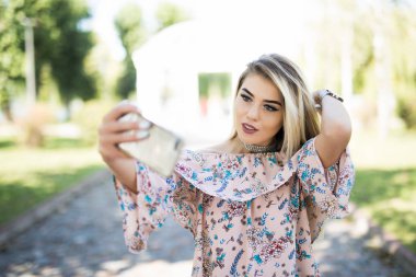 Park yapım selfie fotoğraf telefon gülümseyen bir genç kız portresi