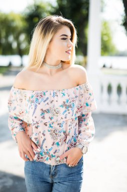 Sokakta neşeli gülümseyen genç kadın. Güzel taze görünümlü sevimli sarışın kız açık havada.