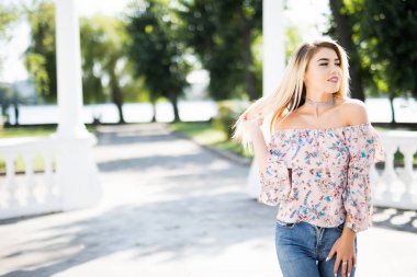 Sokakta neşeli gülümseyen genç kadın. Güzel taze görünümlü sevimli sarışın kız açık havada.