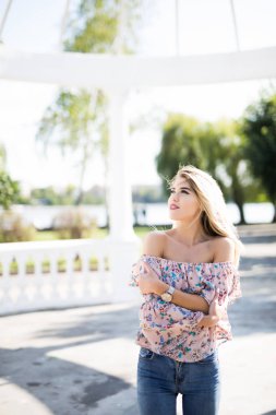 Şık sarışın kadın açık havada. Parkta poz.