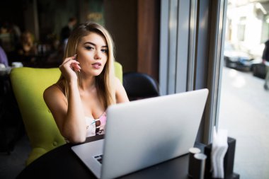 Düşünceli kavramı. Bir kafede bir bilgisayarda çalışan kadın