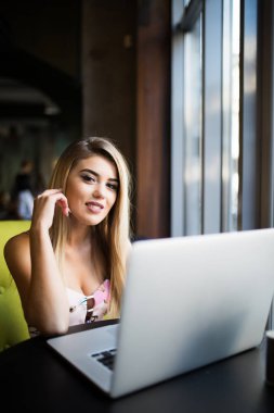 Düşünceli kavramı. Bir kafede bir bilgisayarda çalışan kadın