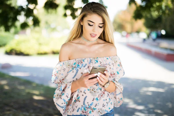 Kadın açık havada manifatura parkta cep telefonunda