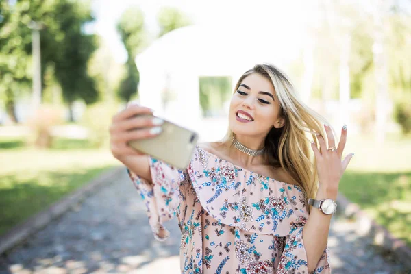 공원에서 selfie 사진 전화를 만드는 웃는 젊은 여자의 초상화 — 스톡 사진
