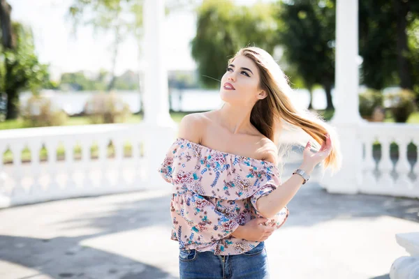 Çekici genç bir kadın parkta eğleniyor.