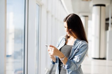 Telefona yazma ve açık havada bir pencereden bakıyor güzel kız