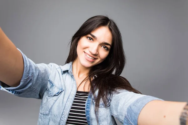 회색 배경 위에 selfie를 만드는 행복 한 젊은 귀여운 여자. — 스톡 사진