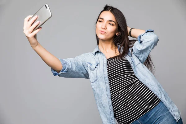 Selfie час. Радісний молоді жінки рішень selfie шляхом її смарт-телефону на сірий фон — стокове фото