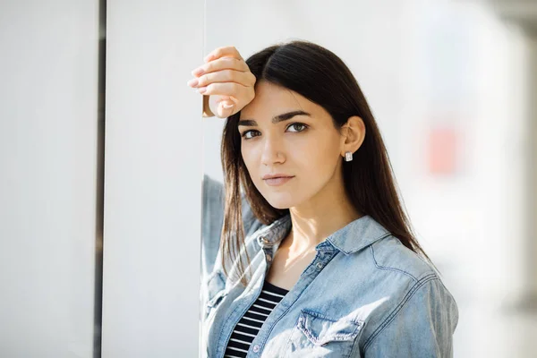 Portrait of a young beautiful girl on a background of a window — Stock Photo, Image