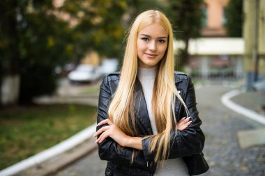 Mutlu güzel kız silah ile ayakta açık havada bir şehir manzarası ile katlanmış