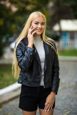 Genç kadın üstünde hareket eden telefon şehirdeki sokak söz