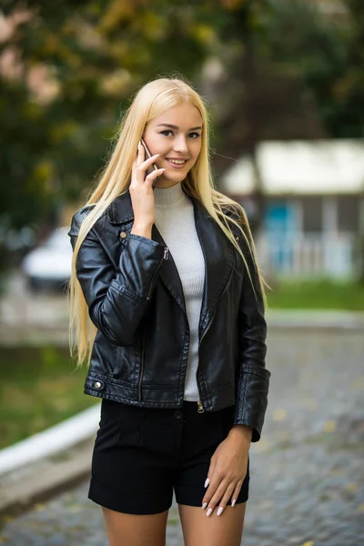 Boldog fiatal nő beszél a mobiltelefon, a város utcai életmód portré. Mosolygó lány cellphone tárgyaláson jó hír. Csinos hölgy hívó telefon szabadtéri. — Stock Fotó