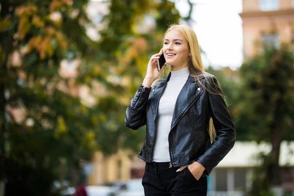 Boldog ifjú hölgy beszél a mobiltelefon az utcát város — Stock Fotó