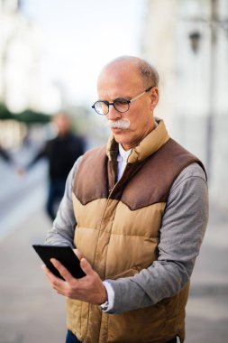 Kablosuz teknoloji aerodinamik benim günlük görevleri tutar. Atış üst düzey bir adam açık havada oturma ve onun tablet vasıl arıyorsunuz.