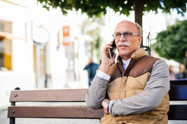 Cep telefonu ile komuta sizde. Ciddi bir yüz olan yaşlı adam. Beni dinle, evlat. Akıllıca bir tavsiyede.