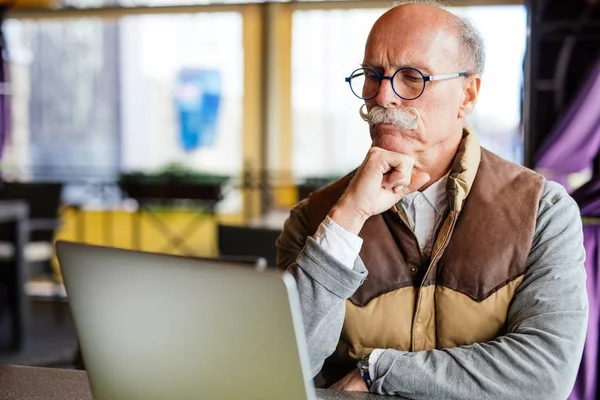 Üst düzey adam akıllı telefon ve kafede dizüstü
