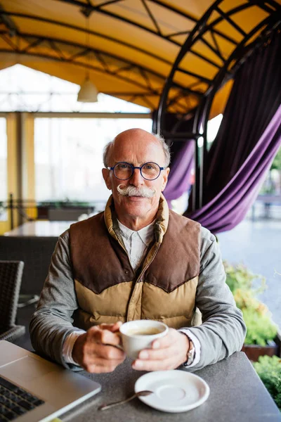 Yaşlı adam bir espresso kafe terasında sahip