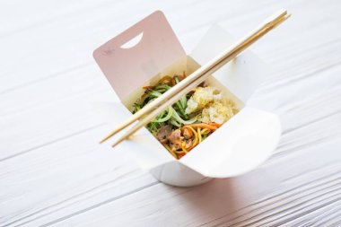 Çin eriştesi ahşap arka plan üzerinde paket servisi olan restoran kutusunda. Gıda.