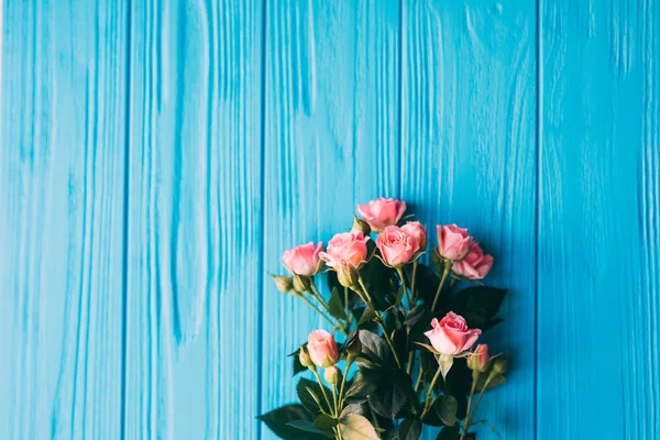 Mavi ahşap arka plan üzerinde güzel pembe güller