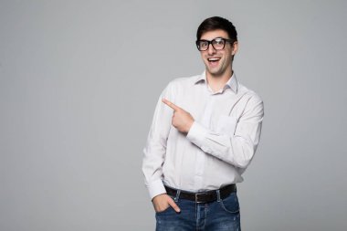 Genç yakışıklı işadamı ışınlama gülümseme gri parmağınızla işaret ile