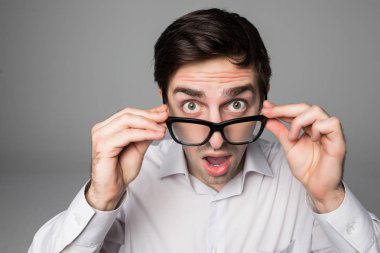 gözlük gri arka planı stüdyosunda tutan girişimci sürpriz