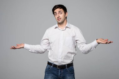 İki ürün gri arka plan üzerinde izole bir denge gösterilen gömlek gülümseyen genç adam.