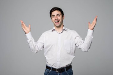 Genç adam portresi ellerinizle gri bir arka plan üzerinde gösterilen kendine güvenen bir işadamı şaşırttı.