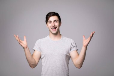 Genç adam portresi ellerinizle gri bir arka plan üzerinde gösterilen kendine güvenen bir işadamı şaşırttı.