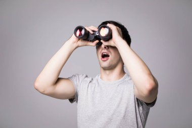 Beyaz arka plan üzerinde izole dürbün ile yakışıklı delikanlı