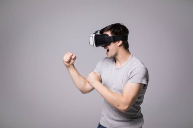 Sanal gerçeklik kulaklık gri arka plan üzerinde izole bir spor mücadele video oyunu oynayan adamla.