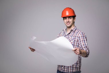 Yakışıklı erkek tarafına bakarak ve gri siyah klasörde tutarak bir siyah takım elbise ve inşaat kask içinde