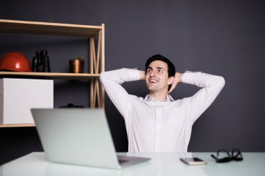 Ofiste başının arkasında elleri olan bir işadamı closeup