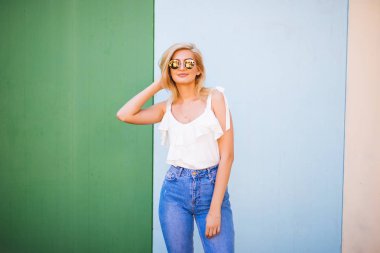 Eğlenceli ve renkli. Renk duvara poz şortlu genç oldukça mutlu kadın.