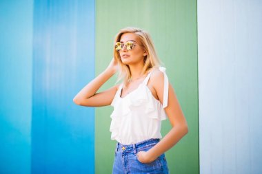 Eğlenceli ve renkli. Renk duvara poz şortlu genç oldukça mutlu kadın.