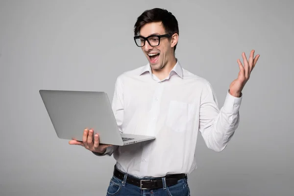 Jeune homme d'affaires choqué et crier en costume avec ordinateur portable dans les mains isolé — Photo