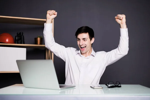 Junge Manager triumphieren mit erhobenen Fäusten im Amt über Laptop — Stockfoto