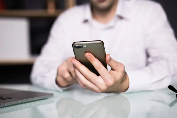 Zakenman met behulp van slimme telefoon in office, hand close-up — Stockfoto