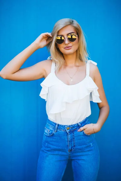 Young girl with long posing on blue background in studio — Stock Photo, Image