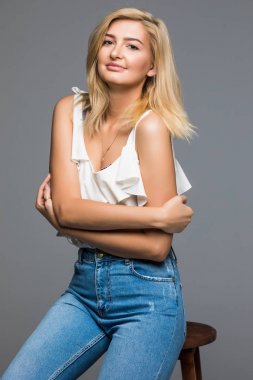 Güzel kadın moda stil geri gri izole sandalyede oturan poz.