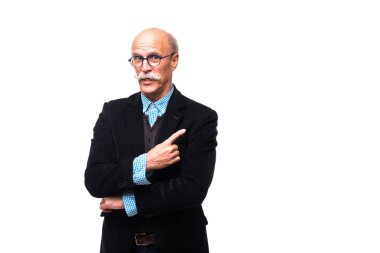 Yakışıklı olgun tarafına işaret ve gri arka plan üzerinde kamera bakıyor