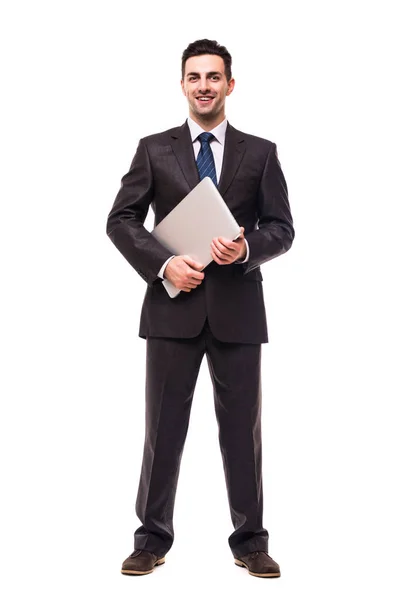 Повна довжина привабливого молодого бізнесмена, який ходить і тримає ноутбук над білим — стокове фото