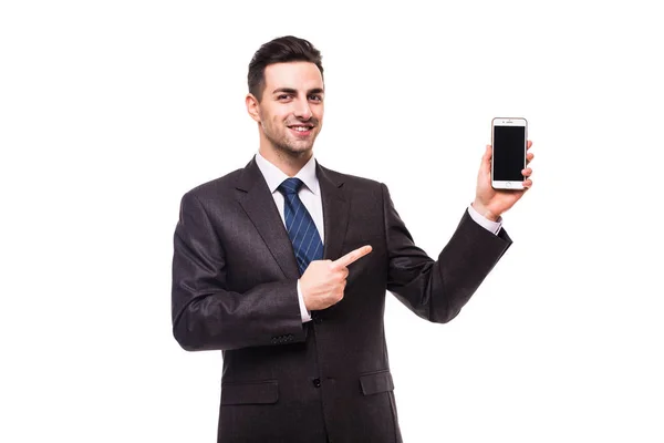 Joven empresario asombrado sosteniendo y apuntando en el teléfono inteligente de pantalla en blanco — Foto de Stock